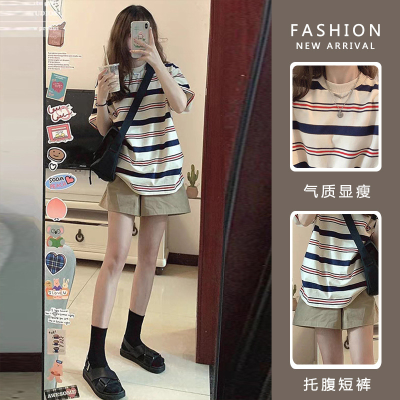 Wearing a casual maternity suit with contrasting striped short sleeved T-shirt, a maternity top and belly support shorts, a maternity outfit
